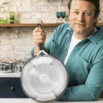 Chef Jamie Oliver segurando a base da frigideira Tefal em aço inox, destacando o fundo triplo para indução