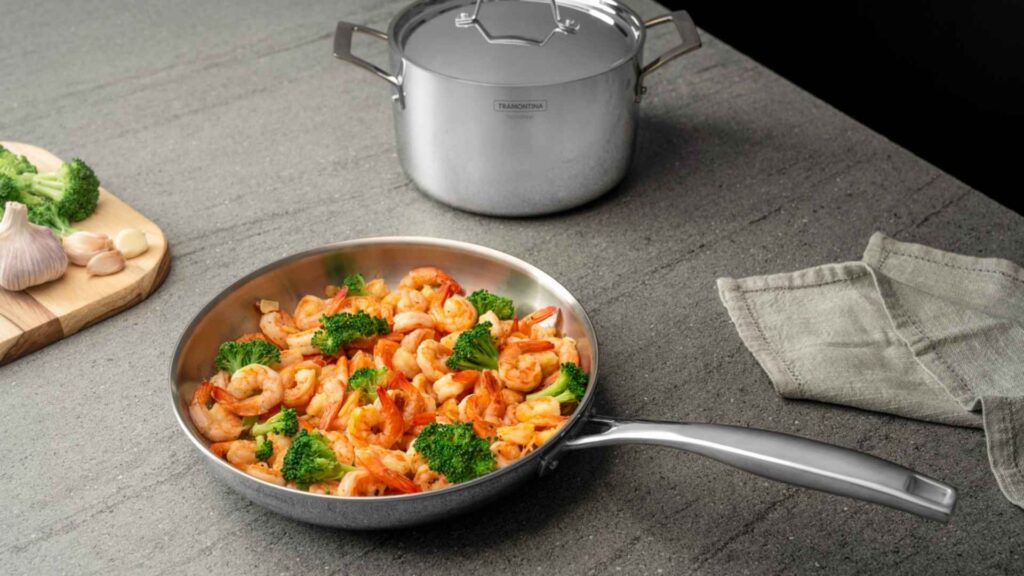Prato de massa servido diretamente na frigideira Tramontina Grano de aço inox sobre uma bancada