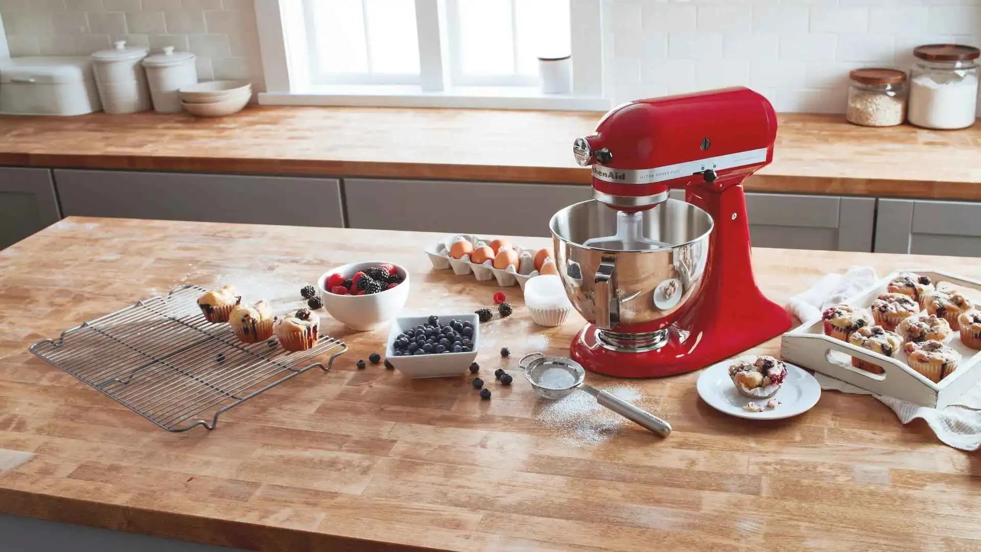 Batedeira KitchenAid Artisan vermelha sobre bancada de madeira na cozinha