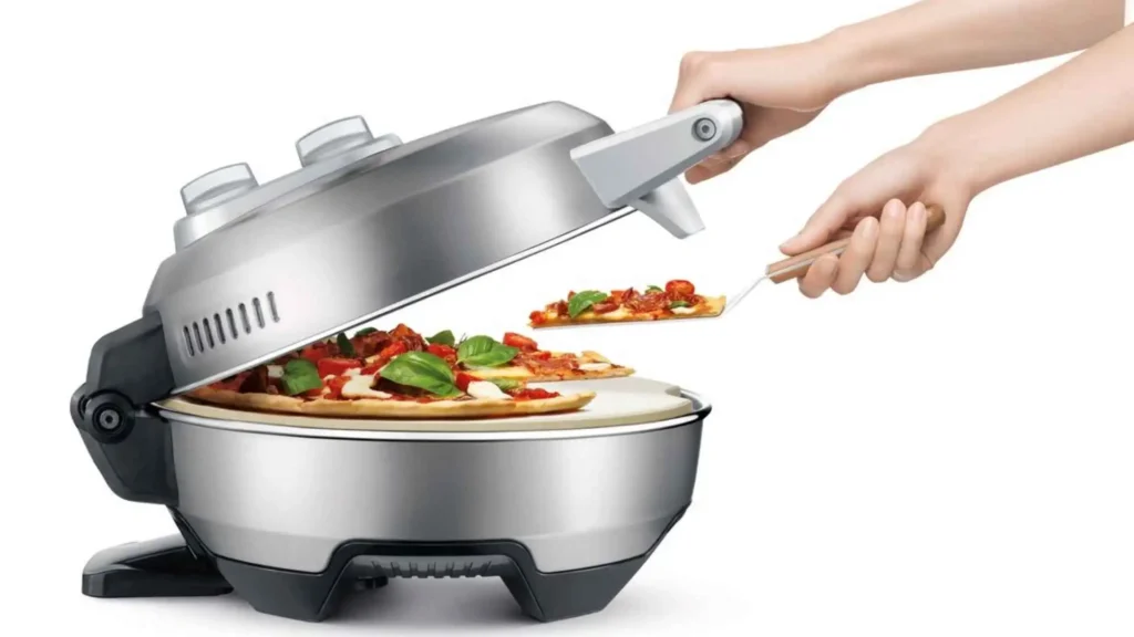 Pessoa utilizando uma espátula para retirar a pizza do forno Tramontina by Breville de forma simples