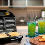 Crepeira Britânia Six aberta em uma bancada de madeira preparando crepes dourados ao lado de dois copos de suco