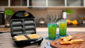 Crepeira Britânia Six aberta em uma bancada de madeira preparando crepes dourados ao lado de dois copos de suco