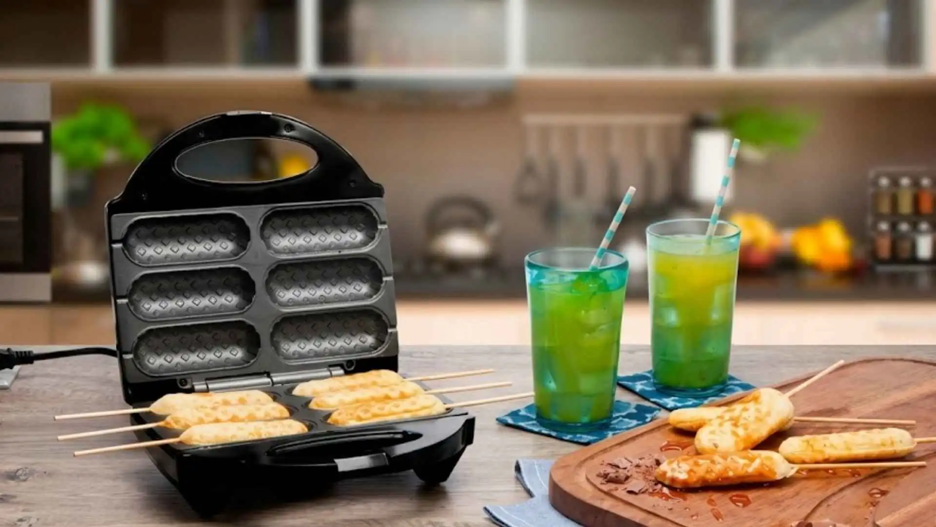 Crepeira Britânia Six aberta em uma bancada de madeira preparando crepes dourados ao lado de dois copos de suco