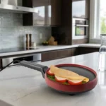 Crepioca Britânia 3 em 1 vermelha sobre bancada de cozinha preparando um omelete dourado