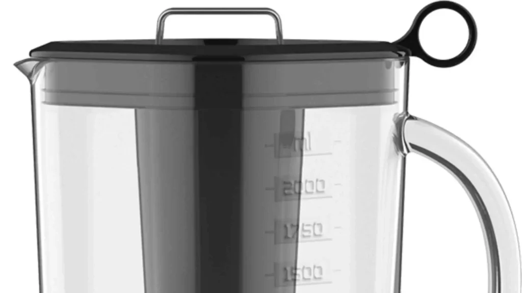 Close da tampa com alça lateral e marcações de medida na jarra transparente do liquidificador Britânia BLQ1300P
