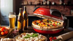 Forno de pizza elétrico Ariete 909 vermelho sobre uma bancada de madeira com ingredientes de pizza ao redor