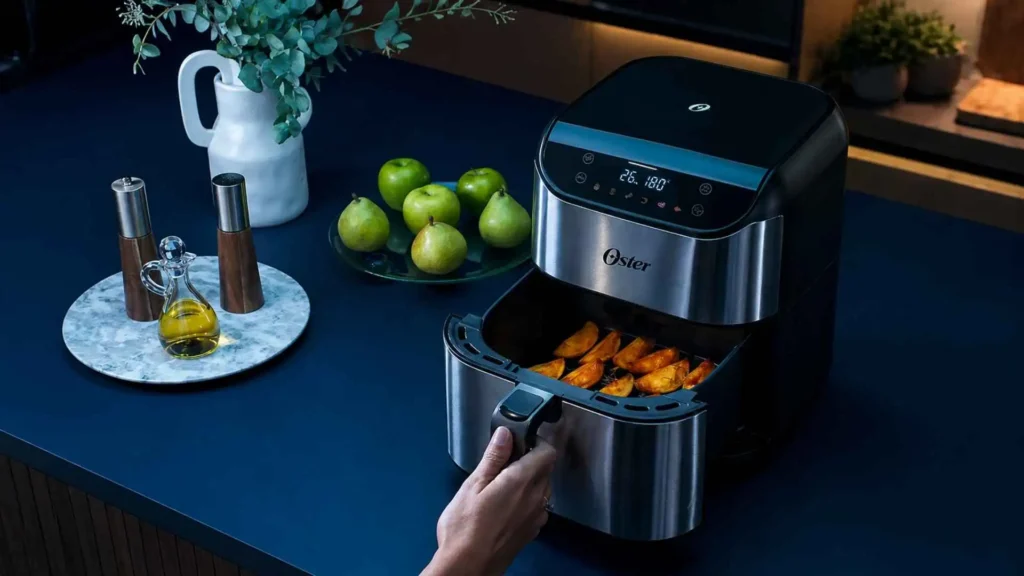 Cesto aberto da Fritadeira Digital Inox Oster 5L mostrando o cozimento uniforme de batatas rústicas