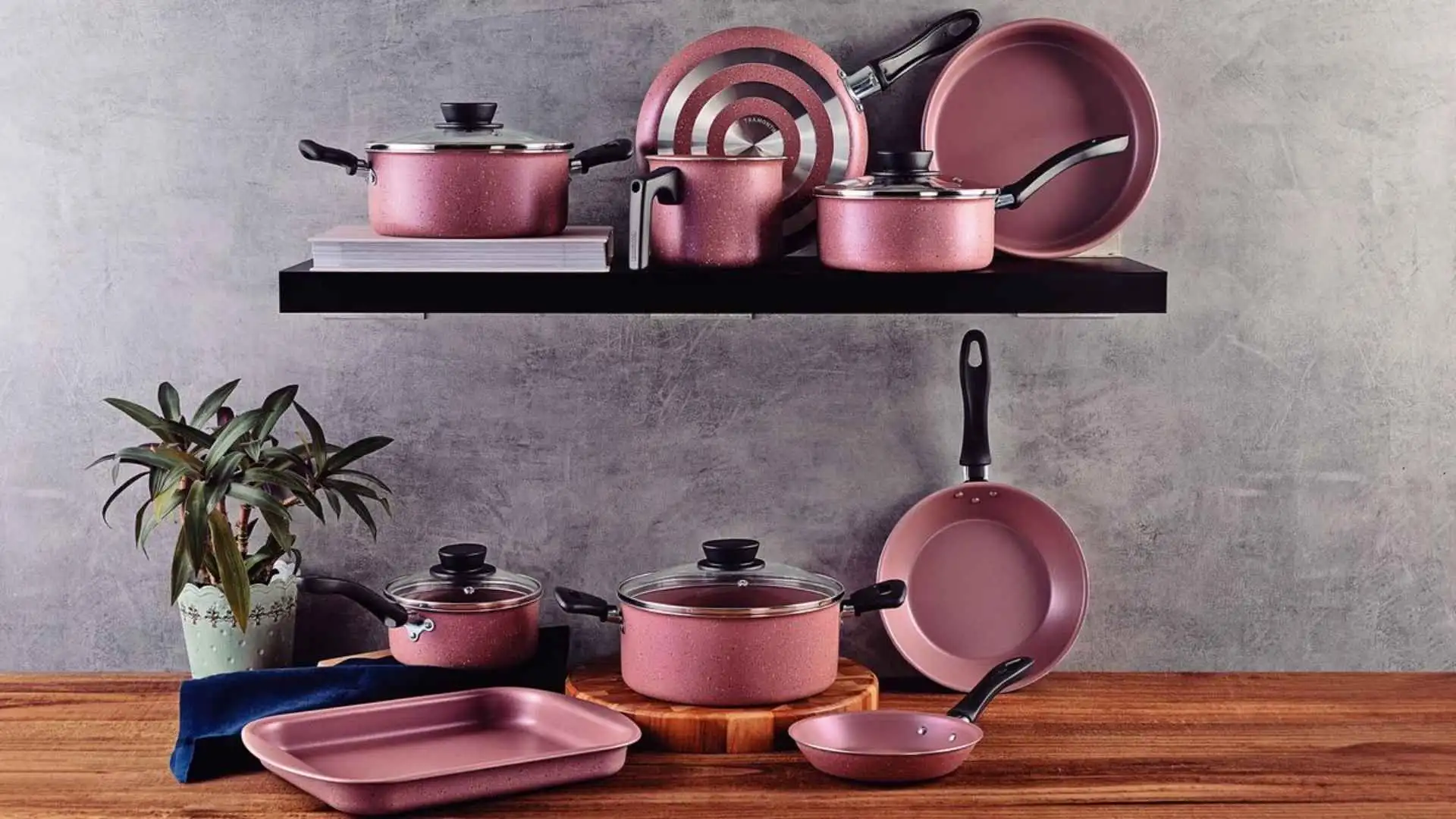 Jogo de panelas Tramontina Linz 10 peças na cor pink com revestimento antiaderente Starflon Max e tampas de vidro temperado sobre uma bancada de madeira