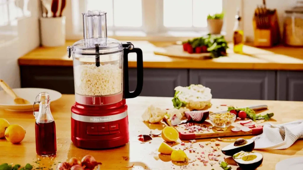 Processador de Alimentos KitchenAid Empire Red preparando ingredientes para receitas sobre uma mesa de madeira