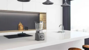 Liquidificador 1100 Full Oster Cinza sobre uma bancada de cozinha moderna branca