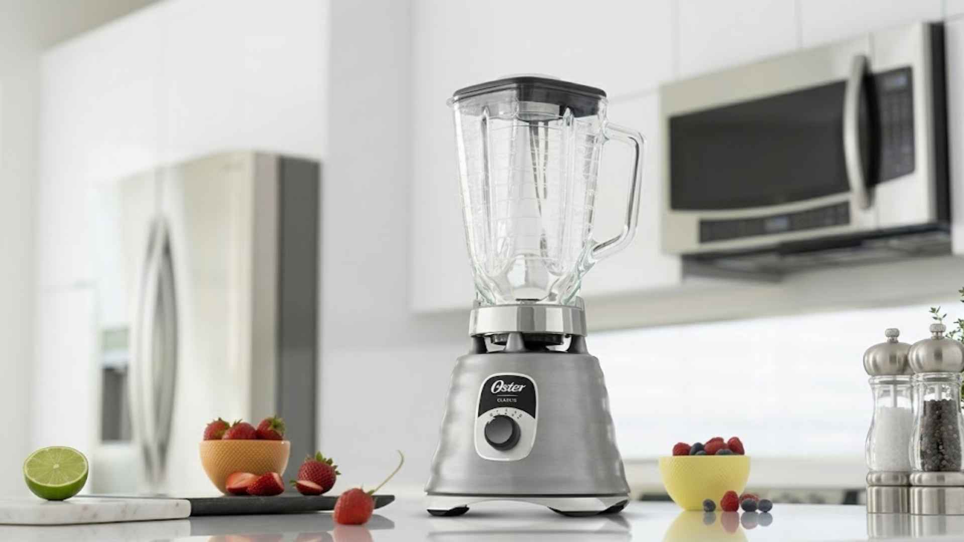 Liquidificador New Osterizer Oster em aço escovado posicionado em uma bancada de cozinha moderna