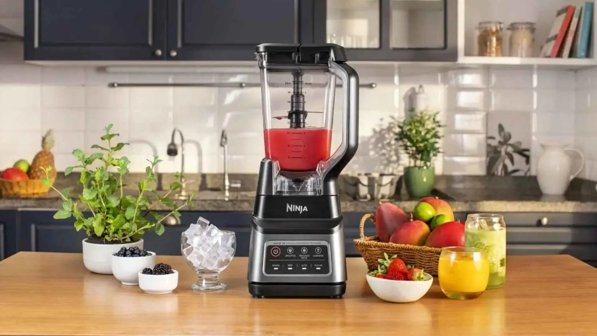 Liquidificador Ninja Standalone Professional Plus preto em uma bancada de madeira ao lado de frutas frescas e um balde de gelo