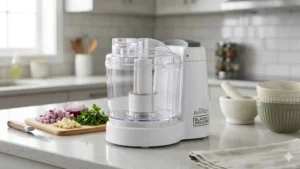 Mini Processador BLACK+DECKER MP120B2 branco posicionado em uma bancada de cozinha, destacando seu design compacto
