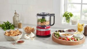 Mini processador de alimentos KitchenAid preparado para fazer homus com grão-de-bico em uma cozinha iluminada