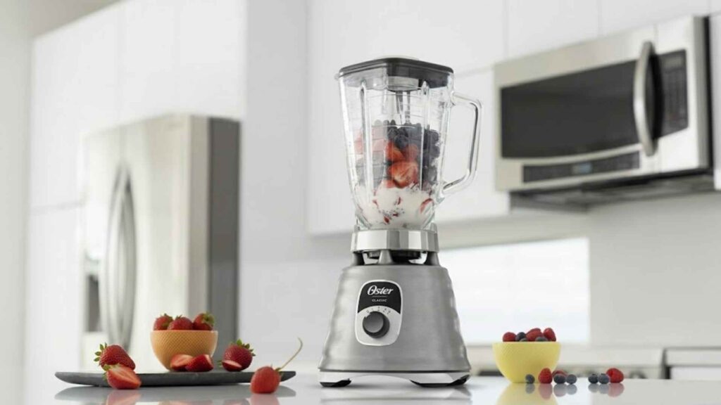 Jarra de vidro do Liquidificador New Osterizer Oster sendo preenchida com ingredientes para uma receita
