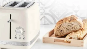 Torradeira Arno Soleil marfim sobre bancada de cozinha com fatias de pão artesanal ao lado