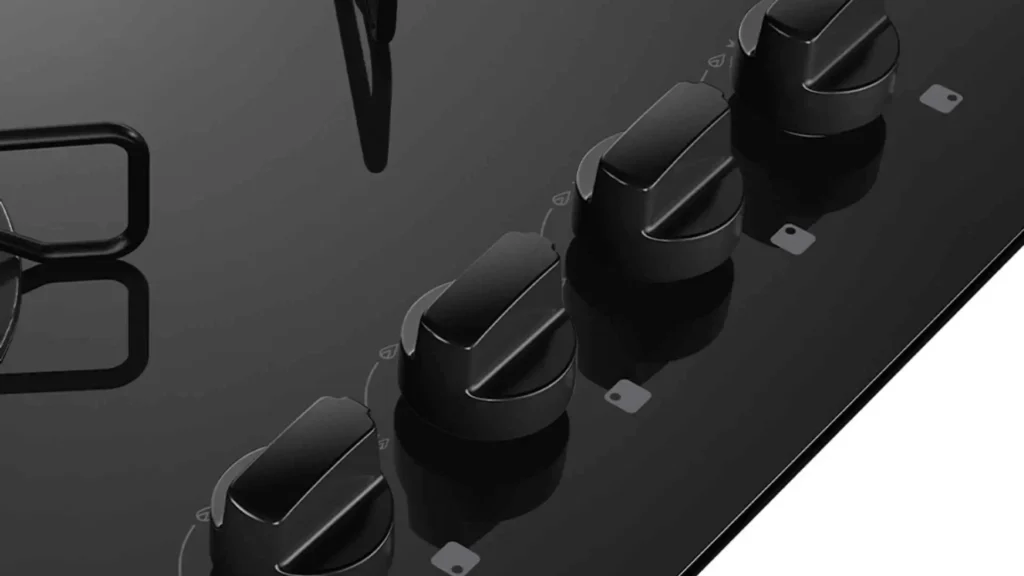 Detalhe aproximado dos botões removíveis pretos na mesa de vidro do cooktop 4 bocas Atlas Agile Up