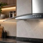 Coifa de Parede Fischer Talent Fit 90 cm com acabamento em inox e vidro curvo instalada na bancada de cozinha planejada
