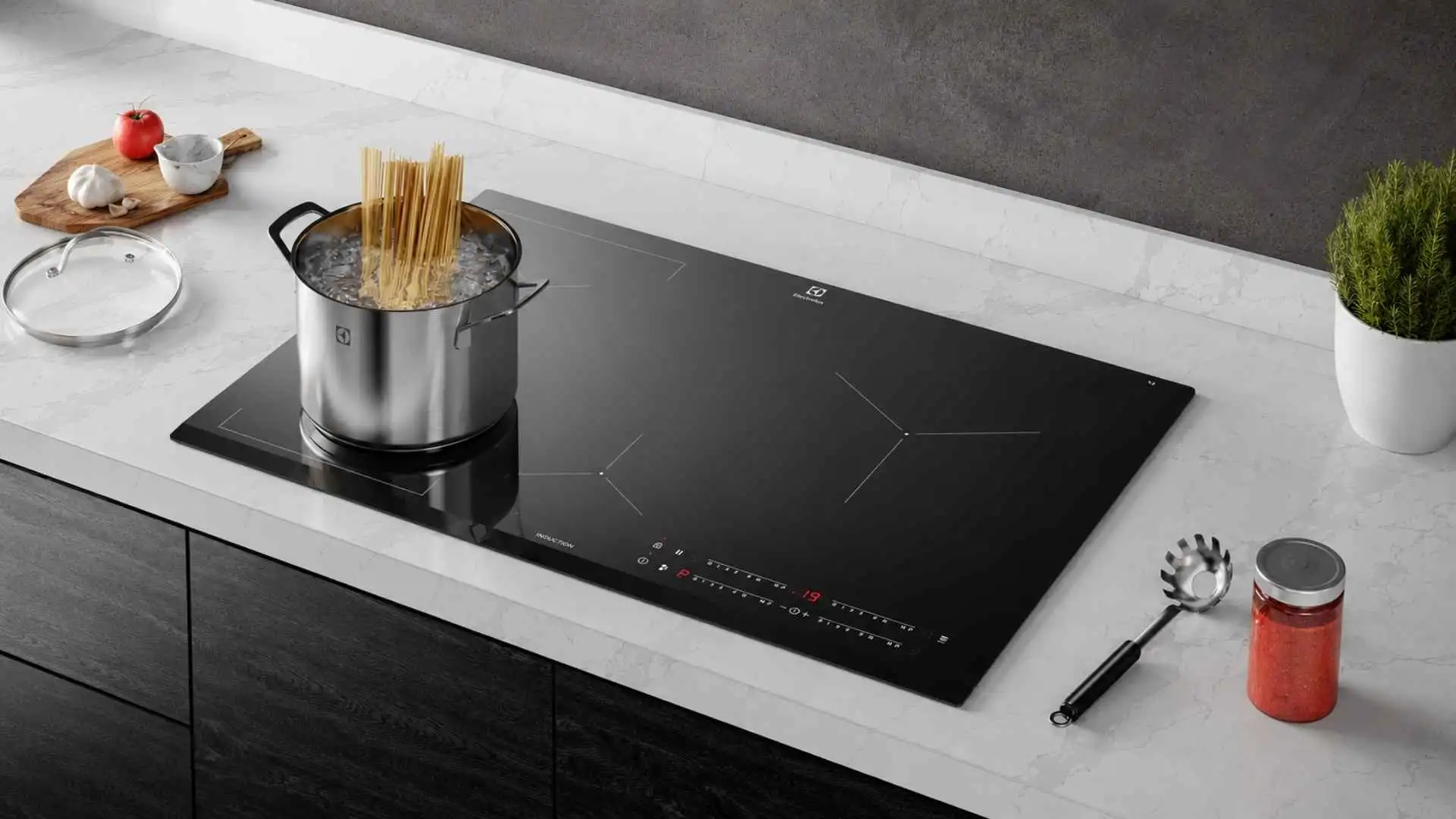 Cooktop 4 bocas Electrolux IE80P de indução embutido em bancada de cozinha clean com panela sobre o queimador