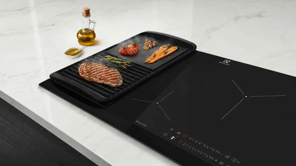 Detalhe da função Unicook ativada no cooktop 4 bocas Electrolux IE80P com uma chapa grill retangular cobrindo duas zonas de cozimento