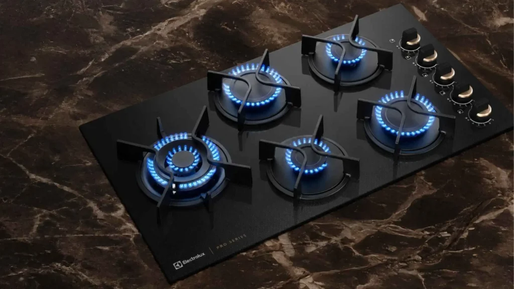 Visão superior em ângulo do Cooktop 5 Bocas Electrolux Pro Series KE5PS mostrando a mesa de vidro temperado preto e o queimador Multi Chama deslocado