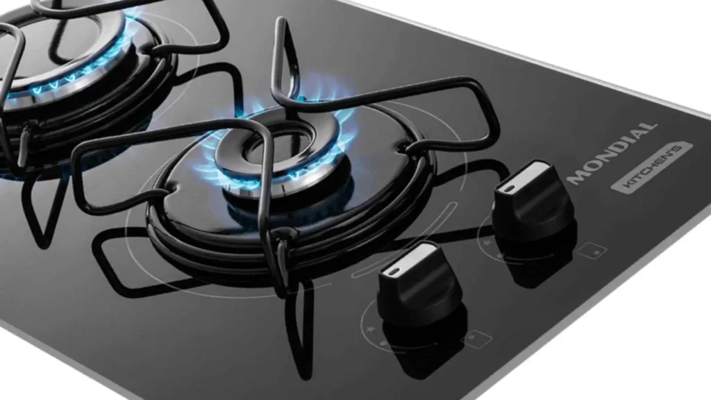 Detalhe aproximado das chamas acesas, trempes individuais e botões com acabamento em inox do cooktop a gás 2 bocas Mondial CTG-04