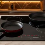Cooktop de indução 4 bocas Oster Touch Screen embutido em uma bancada de mármore clara com panelas em cima