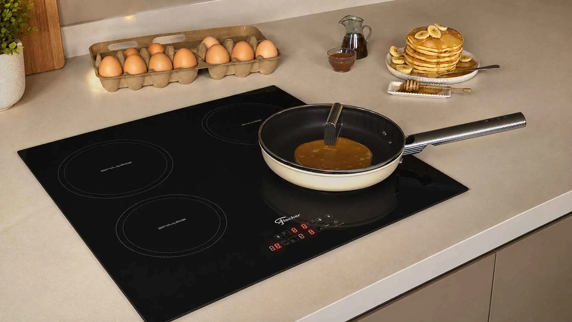 Visão superior do Cooktop de Indução Fischer 4 Bocas Touch Screen em funcionamento com uma frigideira posicionada sobre a mesa vitrocerâmica