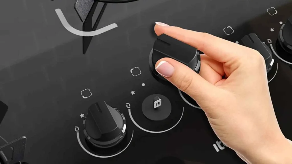 Mão ajustando o botão removível com acendimento superautomático do cooktop Itatiaia Electra 5 bocas