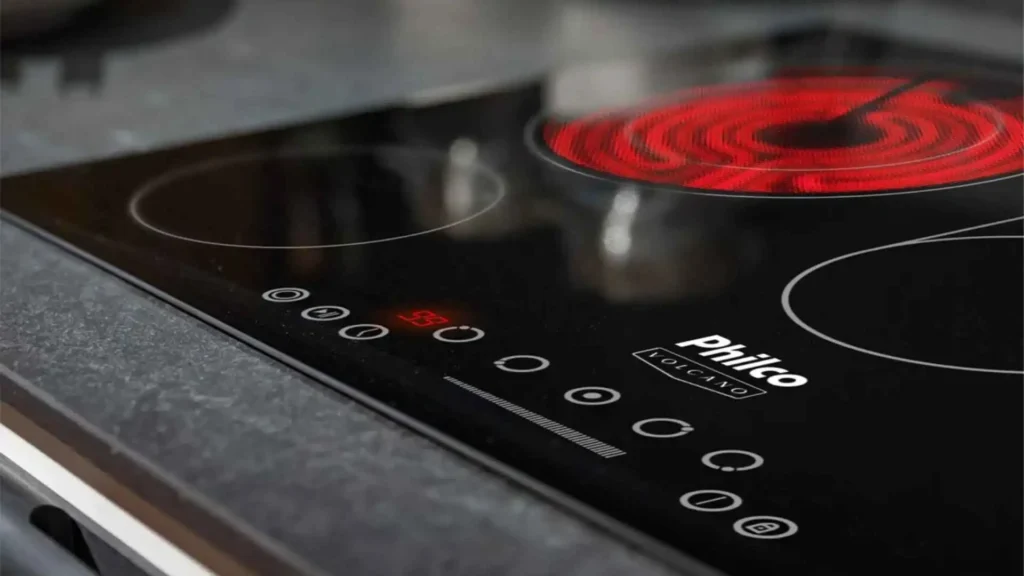 Cooktop Philco PCT55VC com o queimador elétrico traseiro aceso em tom vermelho brilhante por resistência radiante