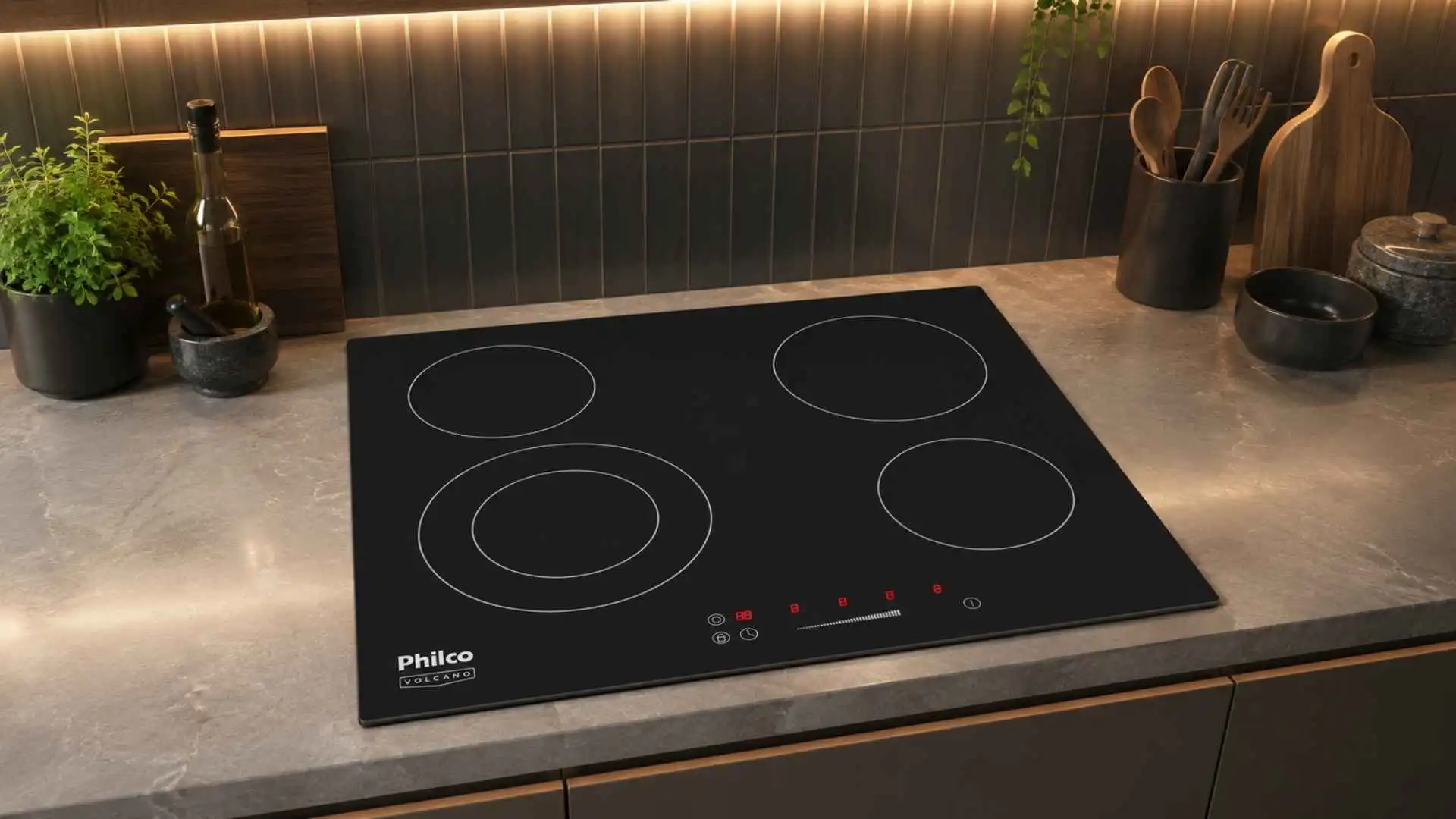 Cooktop Philco Volcano 4 Bocas PCT44VC vitrocerâmico embutido em uma bancada cinza de cozinha planejada moderna com utensílios ao fundo