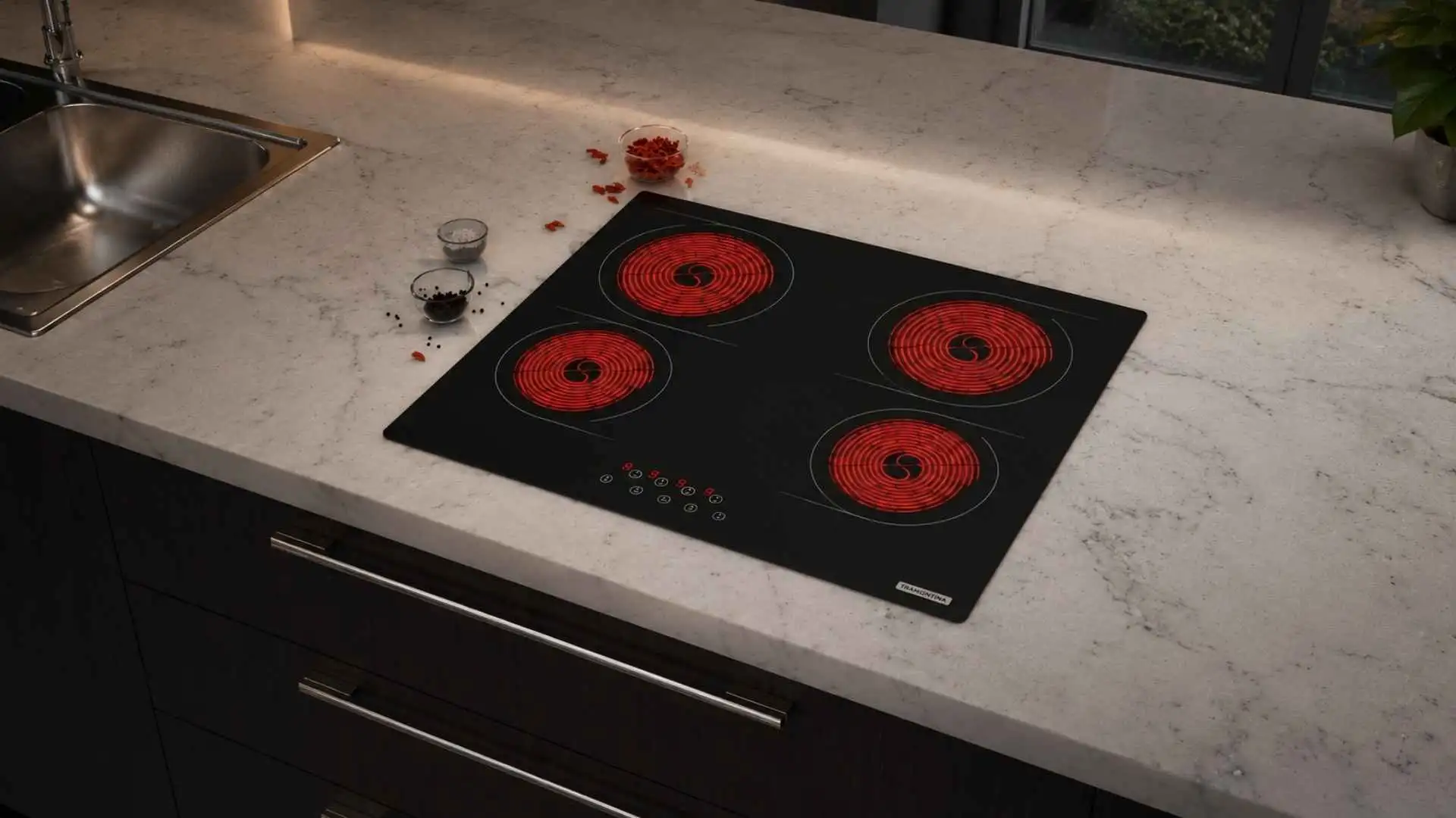 Vista em ângulo de um cooktop Tramontina New Square 4EV embutido em uma bancada de mármore clara com as quatro áreas de aquecimento vitrocerâmicas acesas em vermelho