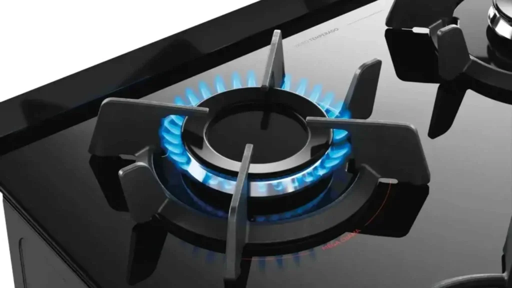 Queimador superpotente com chama azul acesa sobre a mesa de vidro temperado do fogão 4 bocas Dako Supreme Black Glass