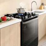 Visão geral do Fogão 5 Bocas Electrolux FE5GB preto com mesa de vidro temperado instalado em uma cozinha moderna planejada com bancada clara
