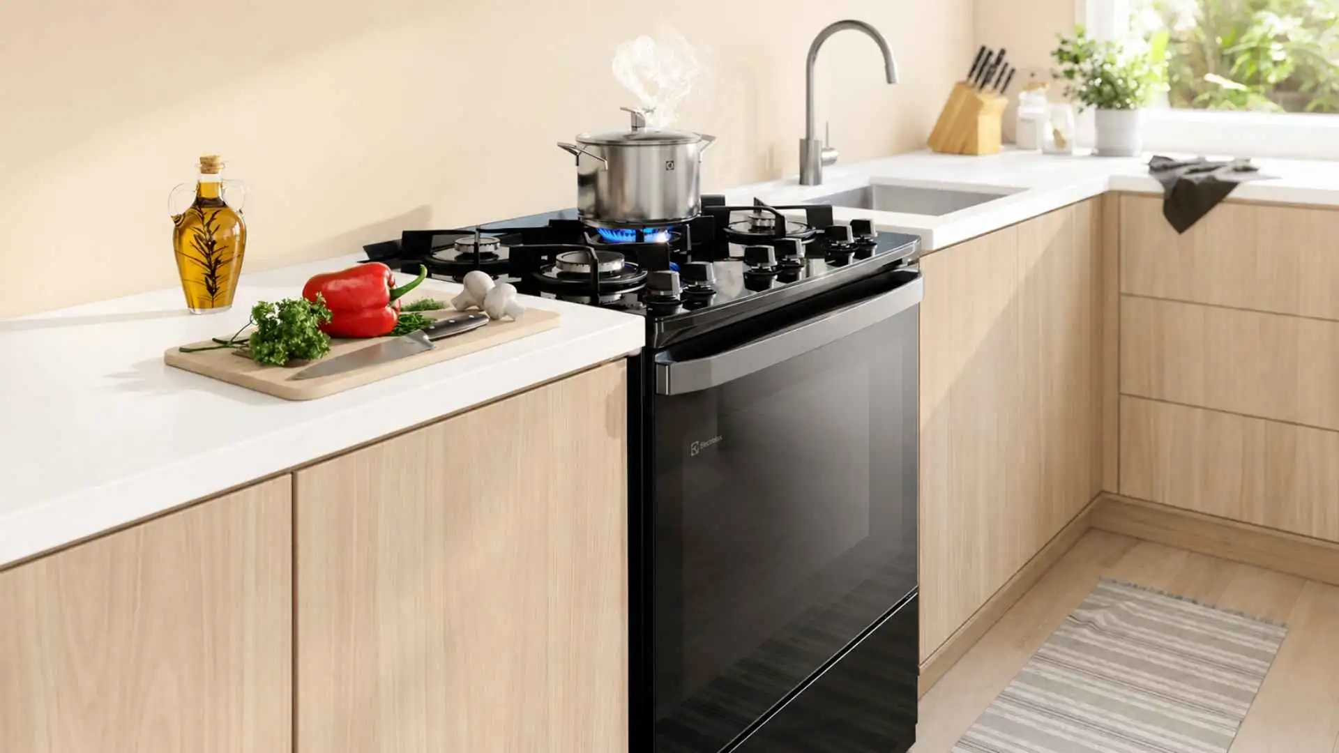 Visão geral do Fogão 5 Bocas Electrolux FE5GB preto com mesa de vidro temperado instalado em uma cozinha moderna planejada com bancada clara