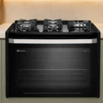 Fogão de embutir 5 bocas Electrolux FE5EB na cor preta instalado em uma bancada de cozinha planejada moderna
