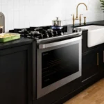 Fogão de embutir 5 bocas Electrolux FE5EC instalado em nicho de bancada preta em cozinha planejada moderna
