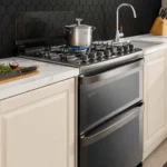 Fogão de piso Electrolux 5 bocas FE5DC Experience cinza com duplo forno instalado em uma cozinha planejada clara