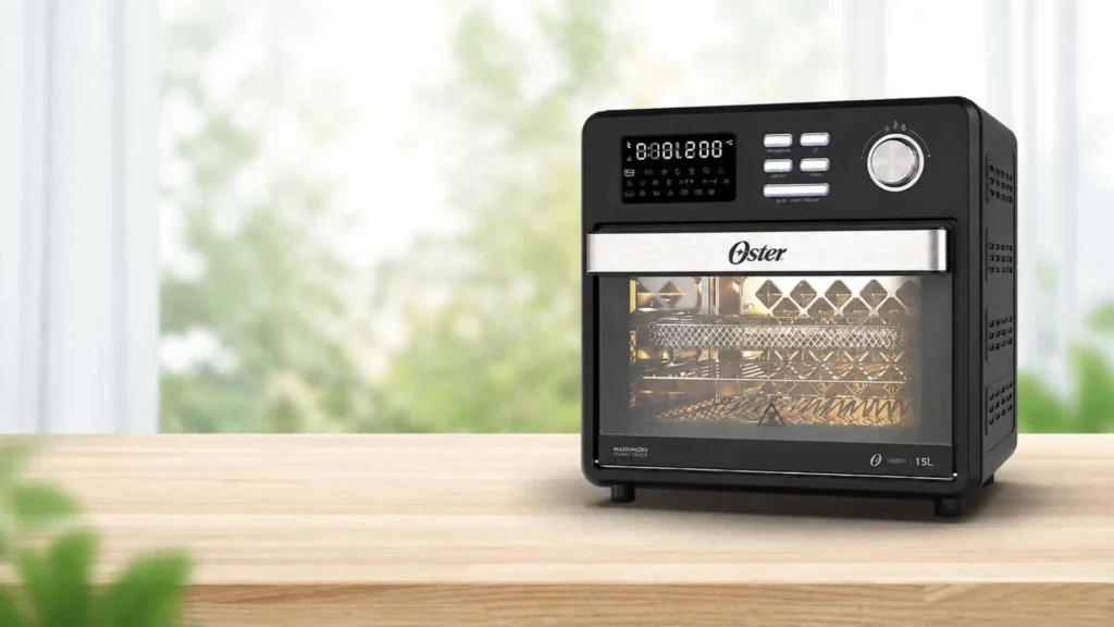 Forno e Fryer 15L Oster 10 em 1 sobre mesa de madeira em ambiente iluminado