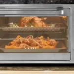 Forno Elétrico Philco PFE40I Air Fry assando frangos inteiros em duas prateleiras, demonstrando a capacidade de 40 litros