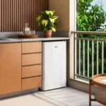 Frigobar EOS 124 Litros EFB131 branco fechado instalado sob a bancada de uma varanda gourmet de apartamento
