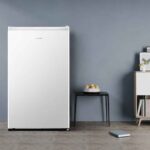 Frigobar Hisense 115 Litros branco com porta fechada posicionado em um ambiente de sala moderno