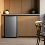 Frigobar Midea 93 Litros Inverter Bivolt com acabamento preto e porta na cor inox instalado em um balcão planejado de varanda gourmet