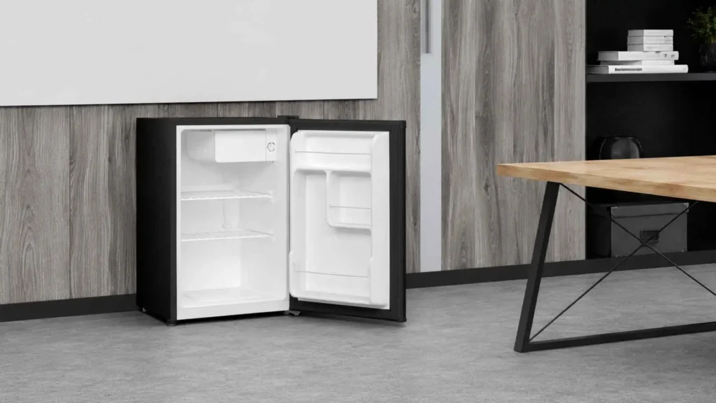 Interior do Frigobar Philco 68L PFG85P vazio, destacando as prateleiras removíveis, o compartimento extrafrio superior e as divisórias da porta para latas