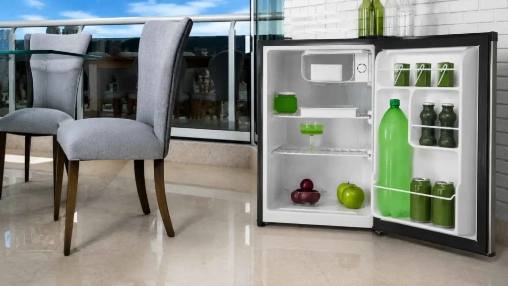 Visão interna do Frigobar Philco PH85 Platinum de 68 litros aberto, mostrando prateleiras abastecidas com latas e garrafas