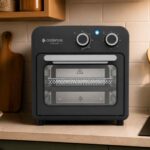 Fritadeira Cadence Classicook 9L preta com visor transparente e botões analógicos em destaque na bancada