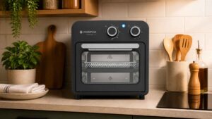 Fritadeira Cadence Classicook 9L preta com visor transparente e botões analógicos em destaque na bancada