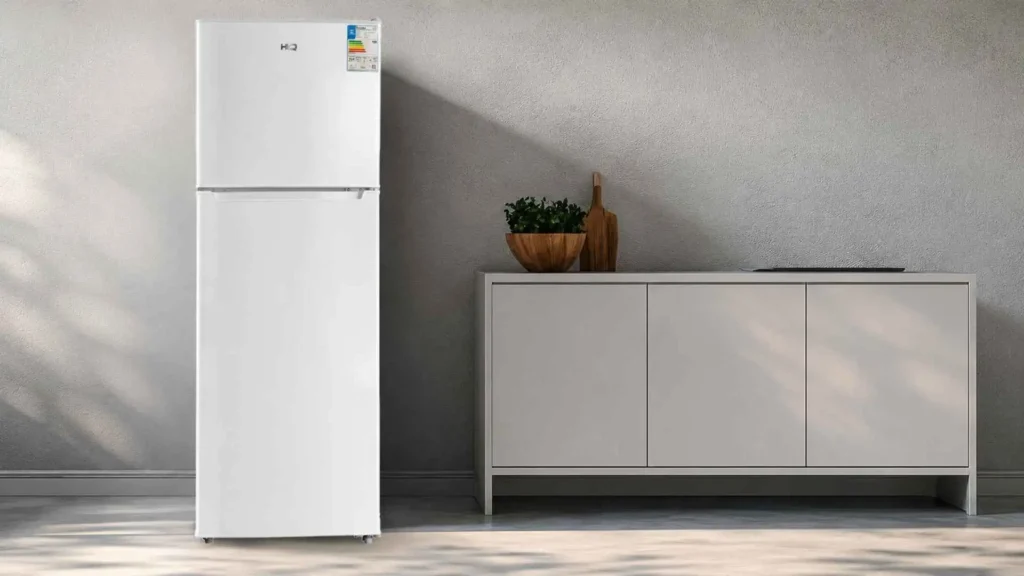 Geladeira HQ Defrost 290 Litros branca de duas portas fechada, posicionada em uma cozinha de design moderno e clean.