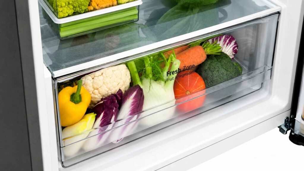 Interior da Geladeira LG Frost Free Inverter 395L mostrando a gaveta Fresh Zone cheia de frutas e legumes frescos
