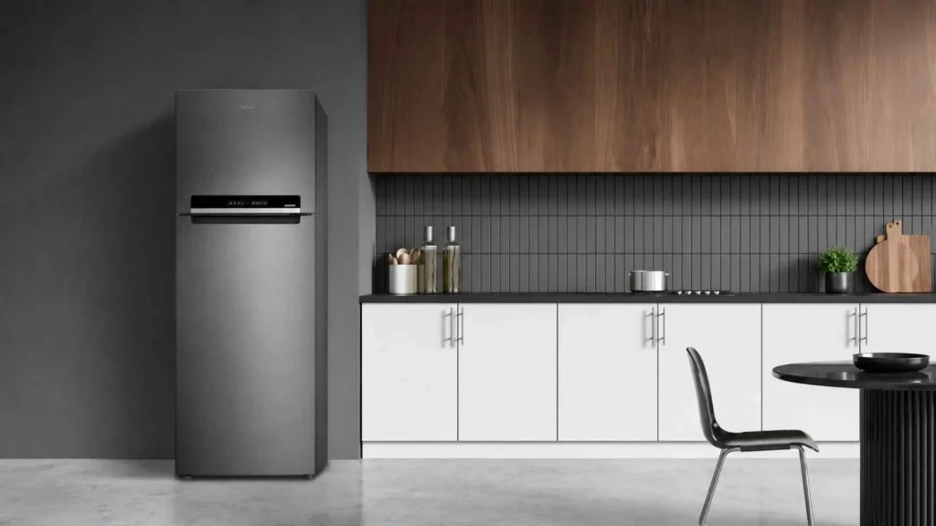 Geladeira Midea 394L Inverter MDRT533 cor inox instalada em uma cozinha moderna com armários brancos e painel amadeirado